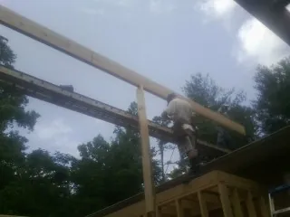 Carpenter setting a ridge beam over a new addition frame — Ice Dam Removal by Roofing Brothers in Cave Springs