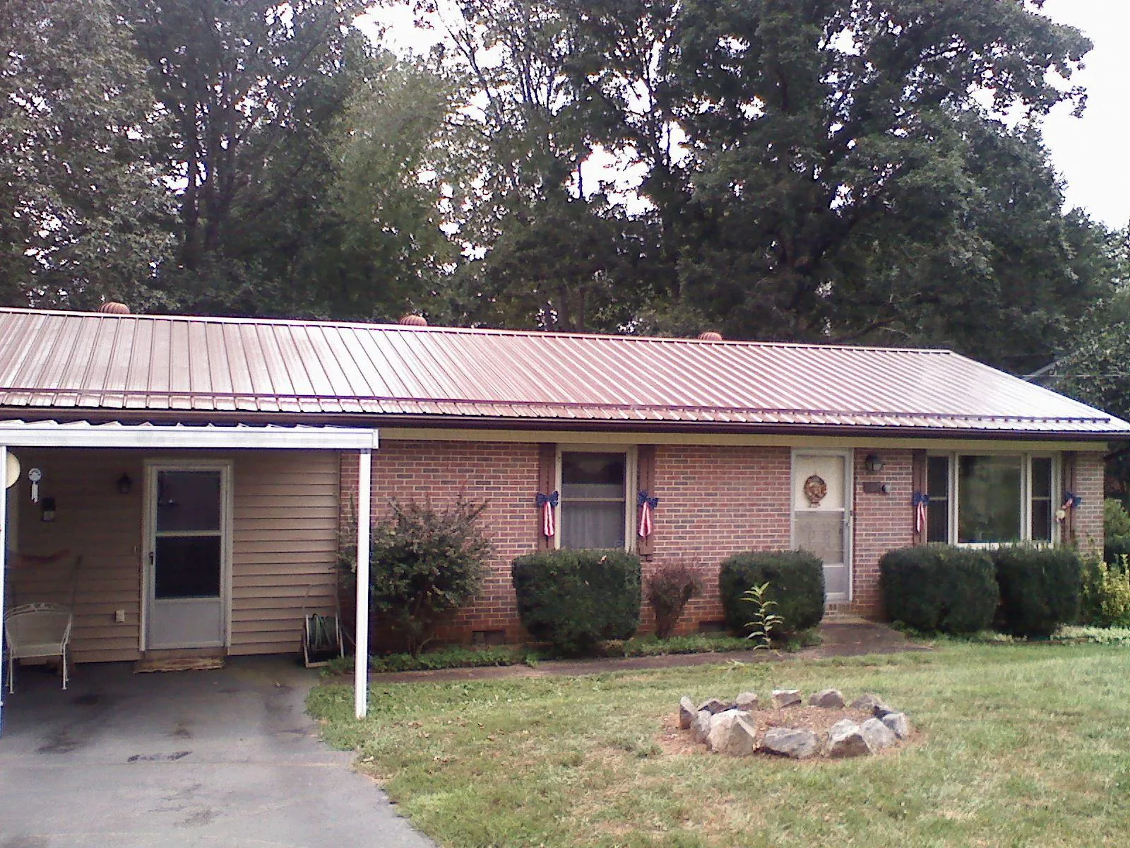 Bronze metal roof and carport on a brick ranch home — Roof Repair work by our crew in Cave Springs
