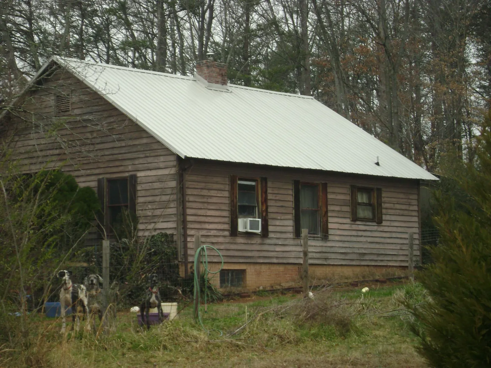 White metal roof on an old wood sided farmhouse, from a Metal Roof Installation job in Cave Springs